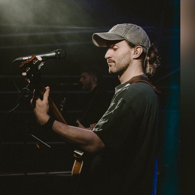 Stephen performing with a guitar and microphone